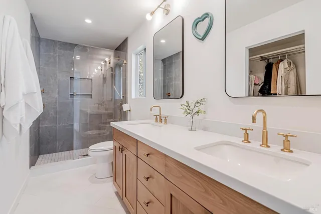 a bathroom with a double vanity sink mirror and toilet