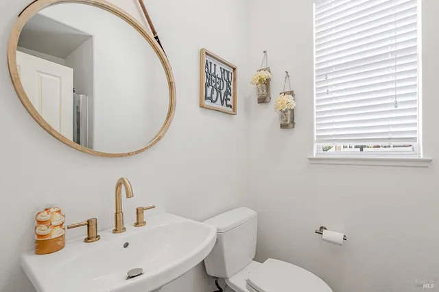 a bathroom with a toilet sink and mirror