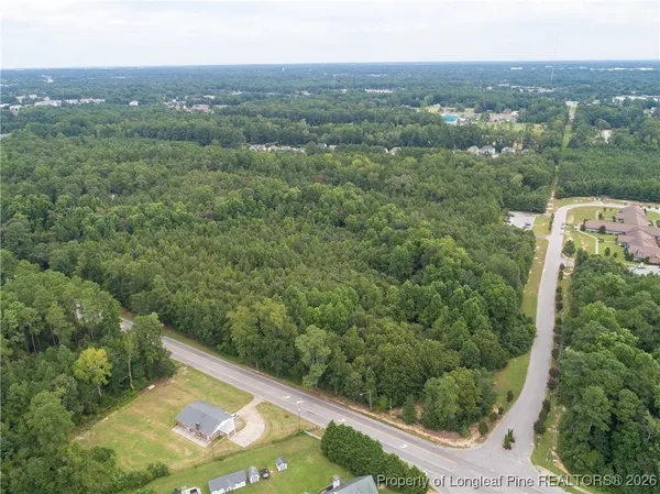 an aerial view of residential houses with outdoor space and trees