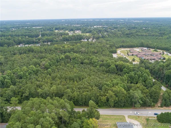 an aerial view of residential houses with outdoor space and trees