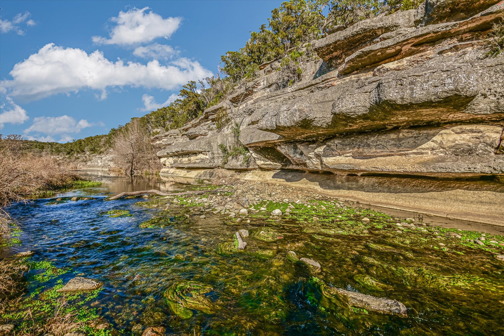 4698 Fischer Store Road Wimberley, TX 78676 - Photo 1 of 28 Dramatic limestone bluffs tower over the clear, winding waters of a scenic Blanco River.