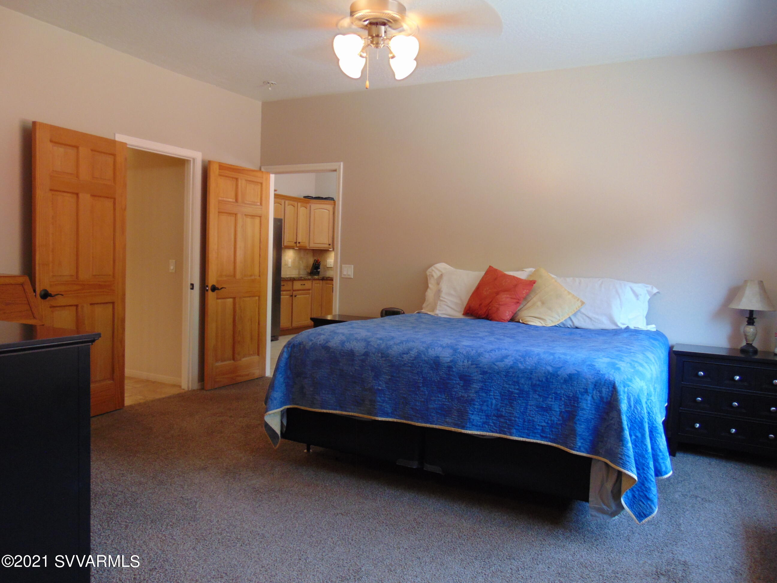 3995 East Beaver Vista Road Rimrock, AZ 86335 - Photo 16 of 40 a spacious bedroom with a bed and a chandelier