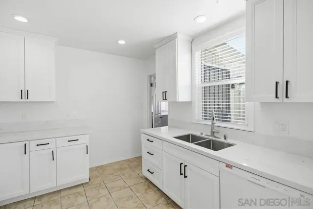 a kitchen with white cabinets and a sink