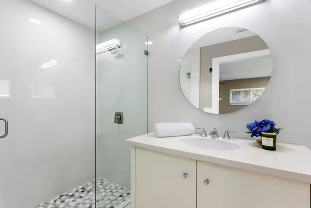 a bathroom with a sink a toilet and shower