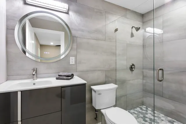 a bathroom with a sink a toilet and a mirror