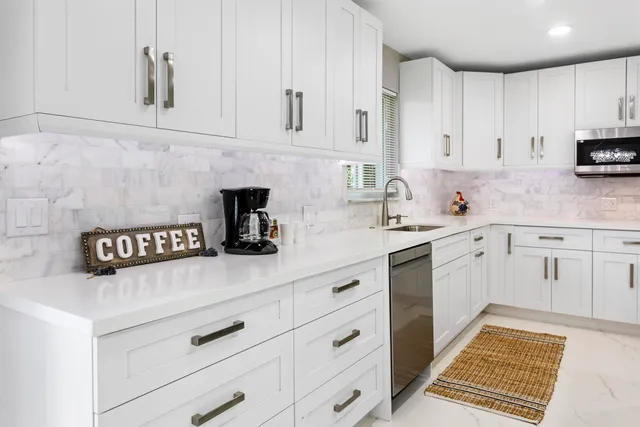 a large white kitchen with cabinets and stainless steel appliances
