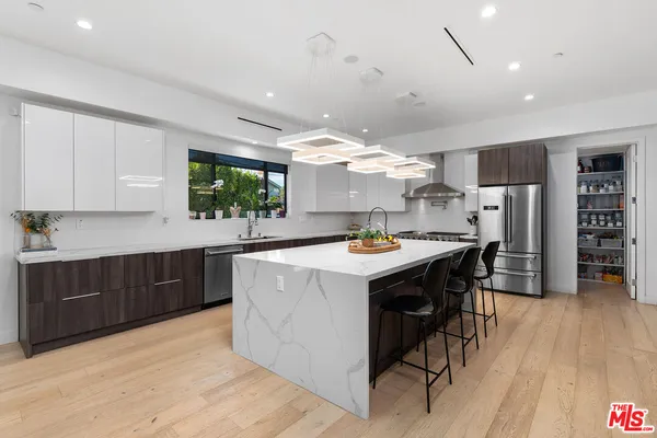 a kitchen with stainless steel appliances kitchen island a large island in the center and cabinets