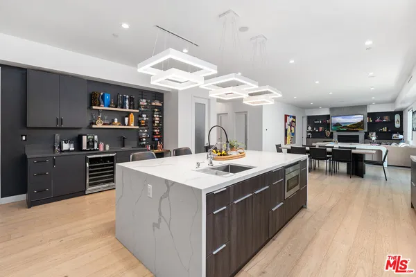 a kitchen with stainless steel appliances granite countertop a stove oven a sink dishwasher and a refrigerator with wooden floor
