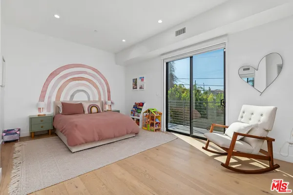a bedroom with furniture and a large window