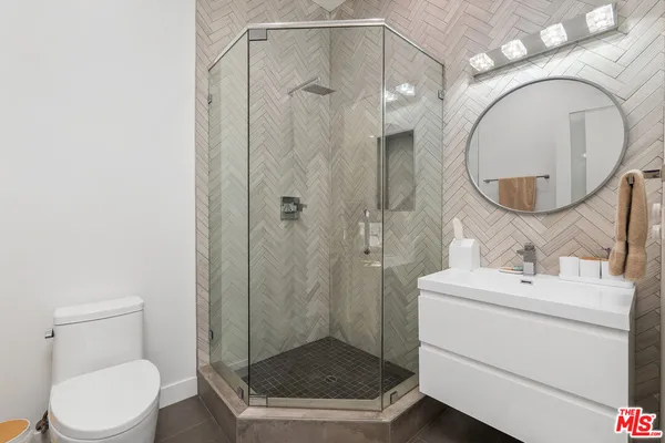 a bathroom with a sink a toilet and a mirror