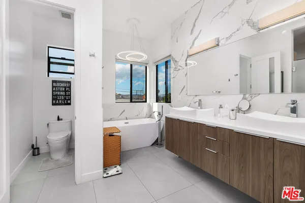 a spacious bathroom with a double vanity sink mirror and toilet