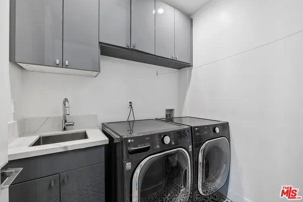 a utility room with sink dryer and washer
