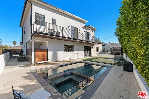 a front view of a house with swimming pool and furniture