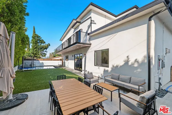 a view of a patio with table and chairs with a garden and plants