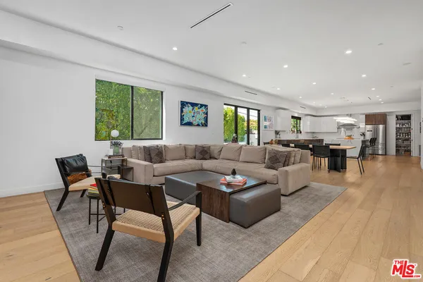 a living room with furniture wooden floor and windows