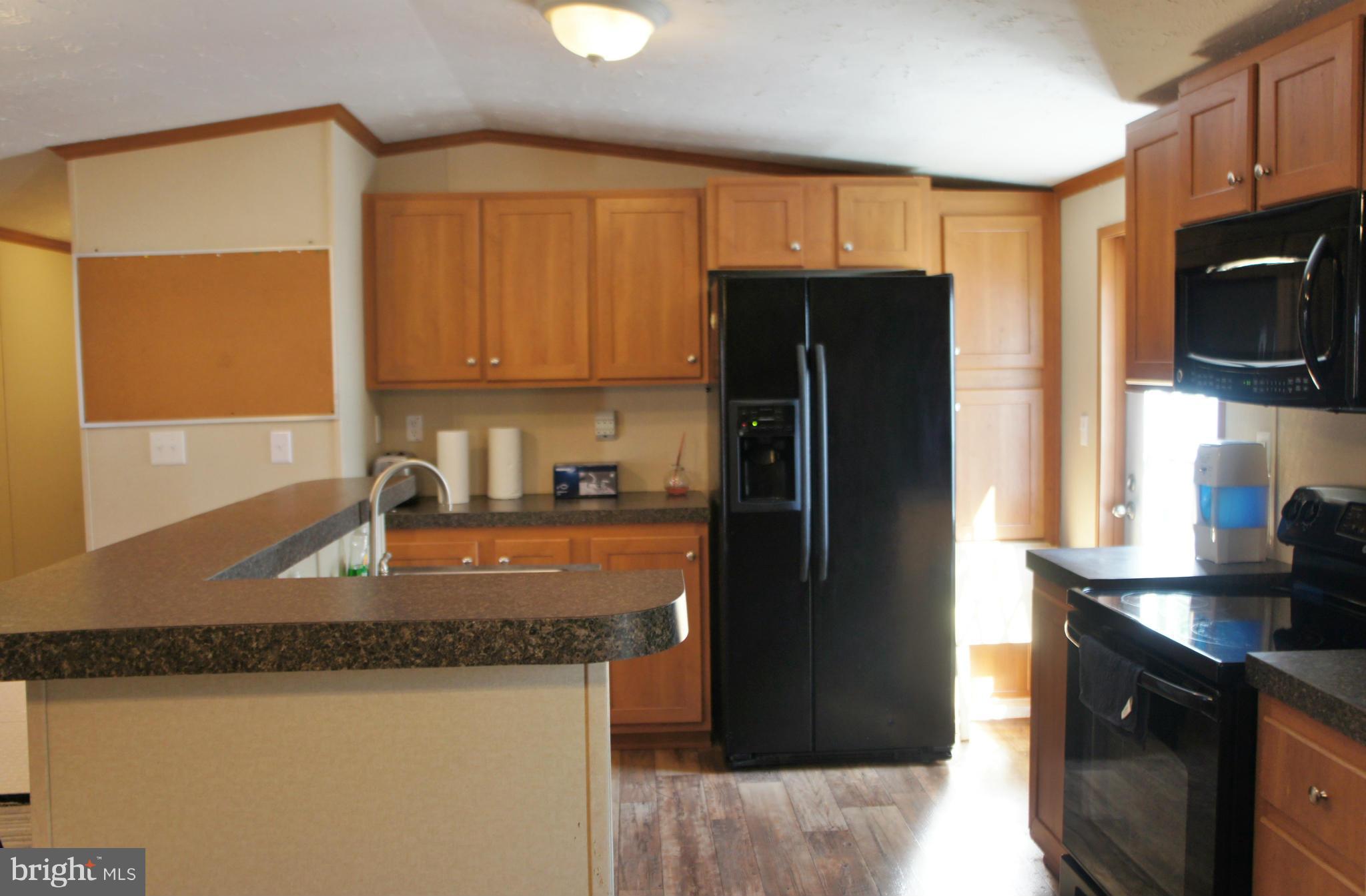 118 German Chapel Road Prince Frederick, MD 20678 - Photo 5 of 27 a kitchen with granite countertop a refrigerator a stove a sink a microwave and cabinets
