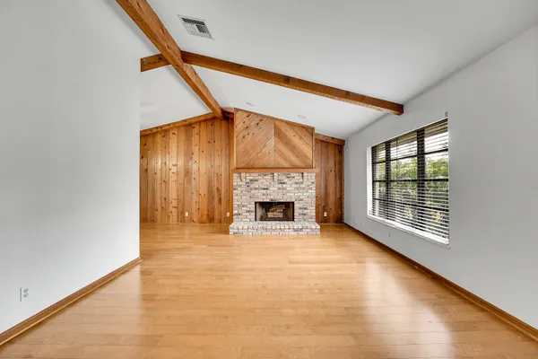 a view of an empty room with a fireplace and a window