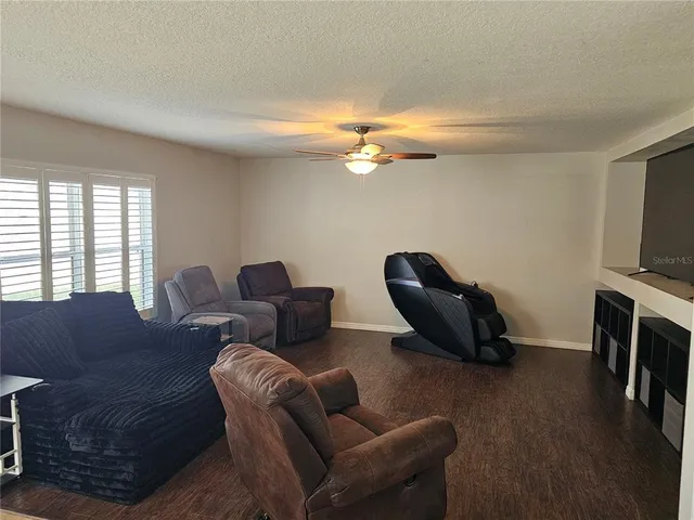 a living room with furniture a flat screen tv and a window