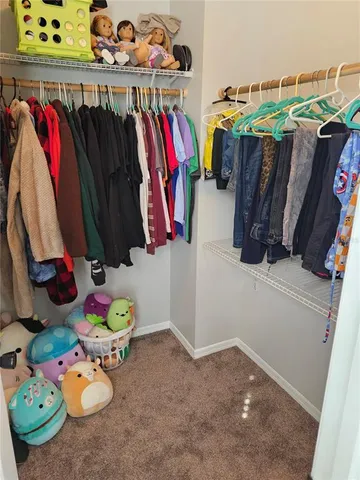 a view of walk in closet with clothes and shoes