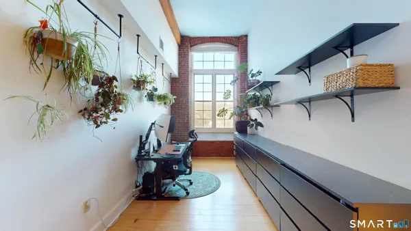 a view of a hallway with wooden floor and a living room