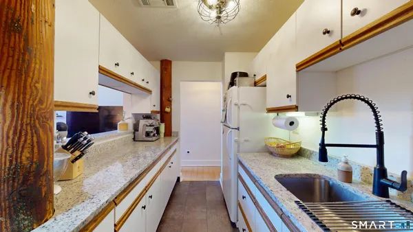 a kitchen with stainless steel appliances granite countertop a sink a stove and a refrigerator