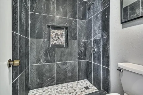 a bathroom with a toilet and a shower