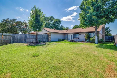 a view of a house with a backyard and a tree