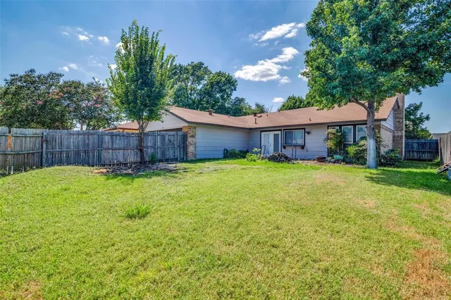 a view of a house with a backyard and a tree