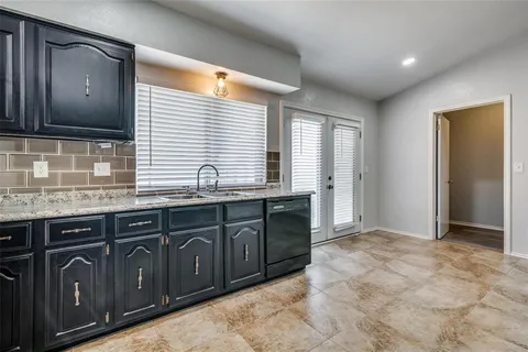 a bathroom with granite countertop a sink and a wooden cabinets