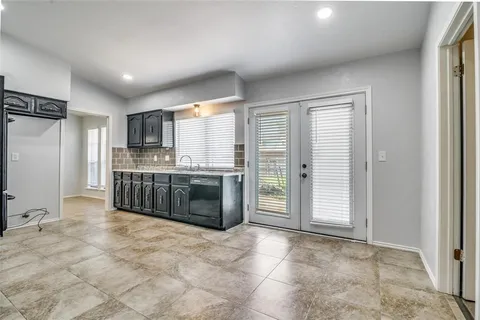 a large kitchen with stainless steel appliances a stove a sink and a refrigerator