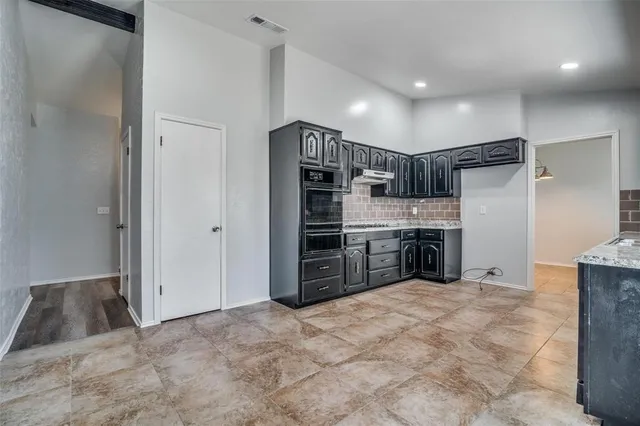 a view of a kitchen with microwave and a refrigerator
