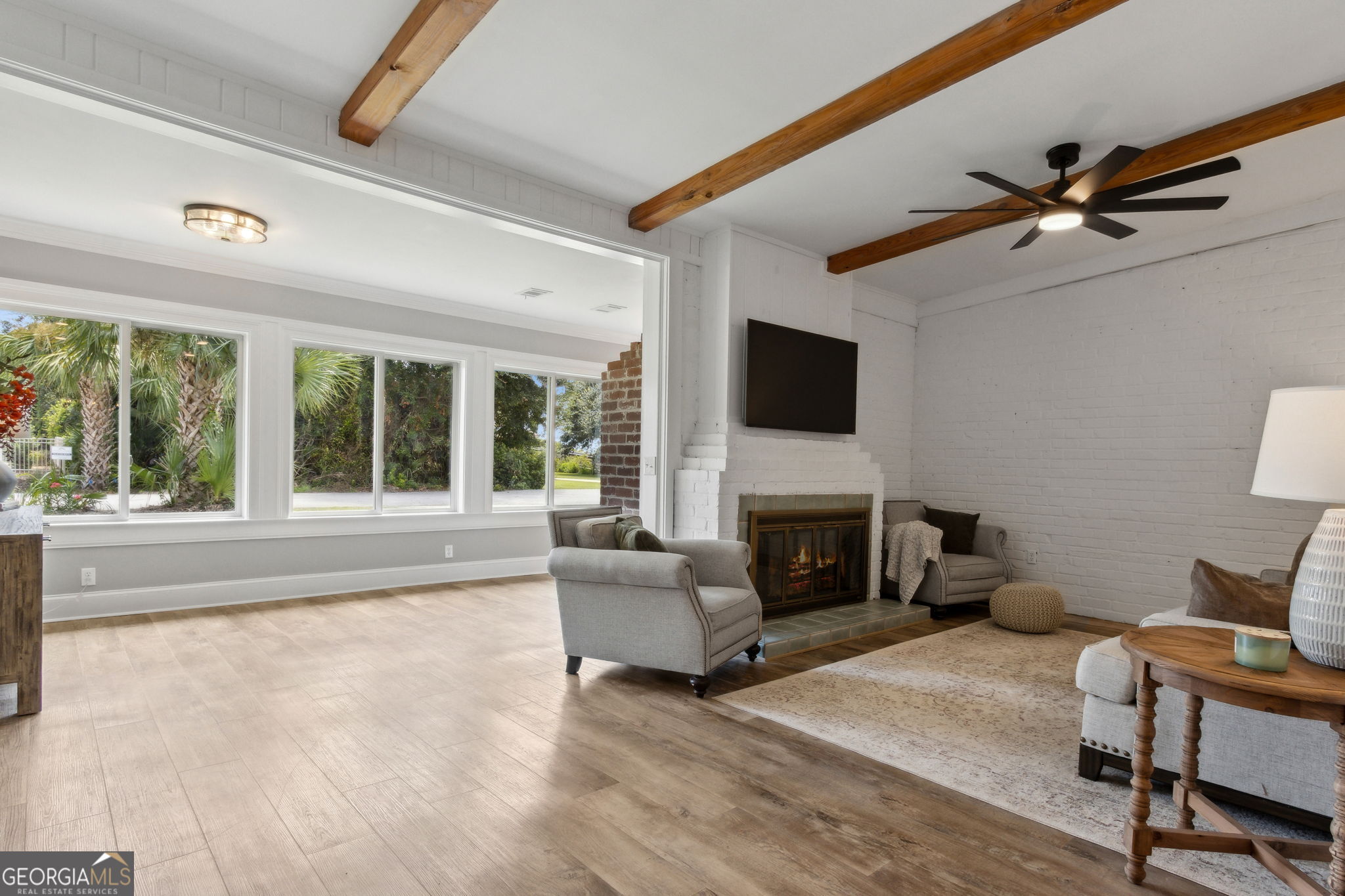 6 Stewart Lane Jekyll Island, GA 31527 - Photo 11 of 95 a living room with furniture a fireplace and a flat screen tv