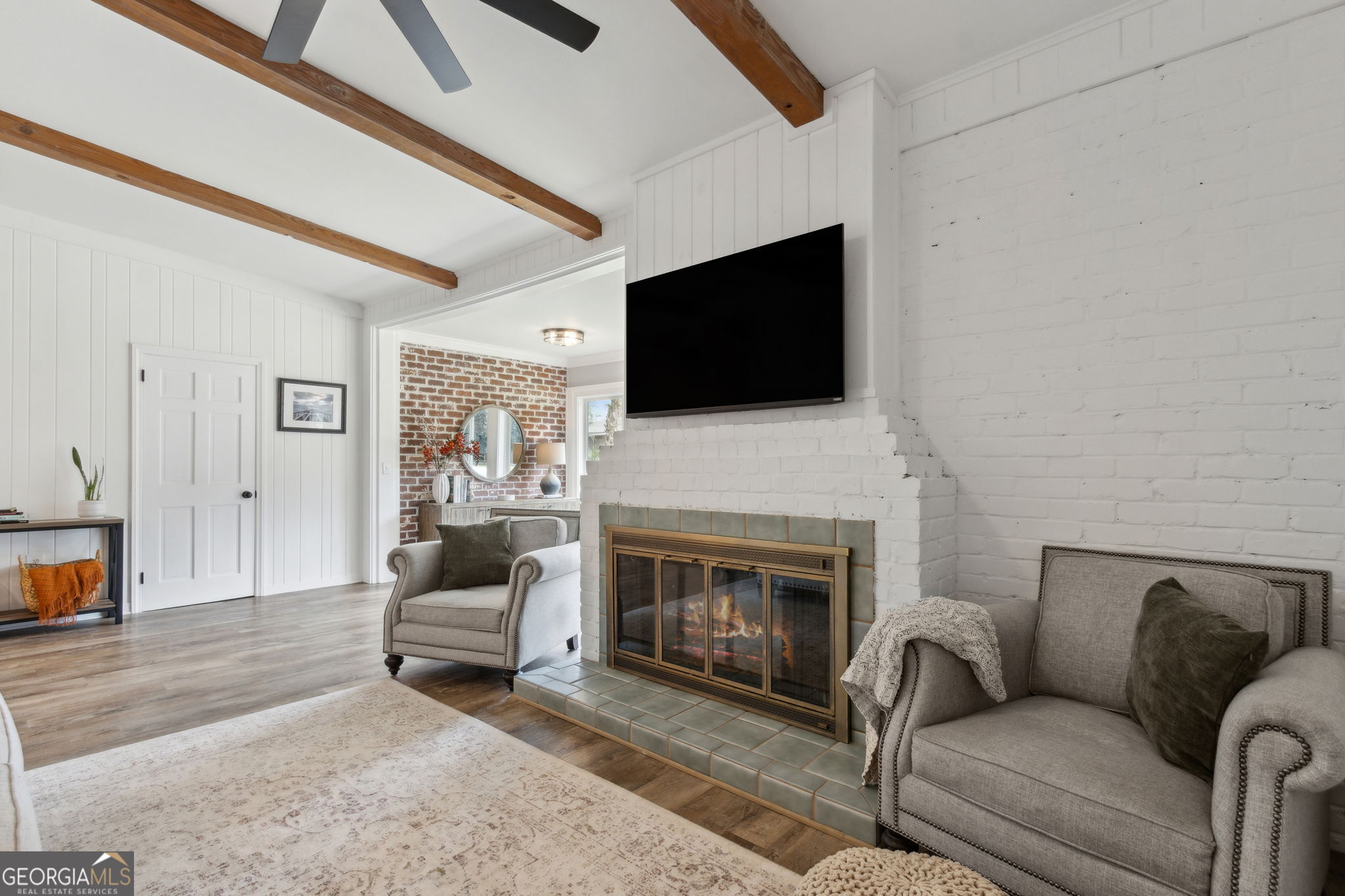 6 Stewart Lane Jekyll Island, GA 31527 - Photo 13 of 95 a living room with furniture a fireplace and a flat screen tv