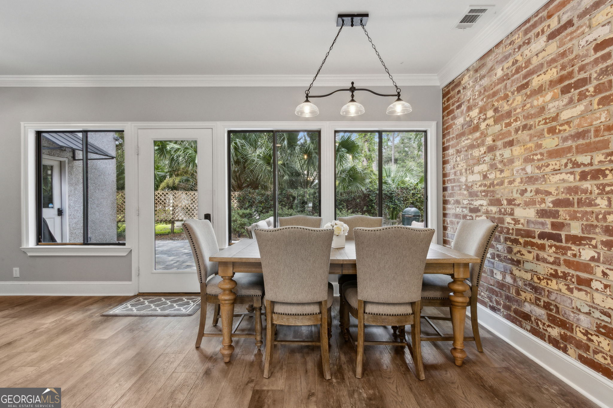 6 Stewart Lane Jekyll Island, GA 31527 - Photo 21 of 95 a dining room with wooden floor a chandelier a wooden table and chairs