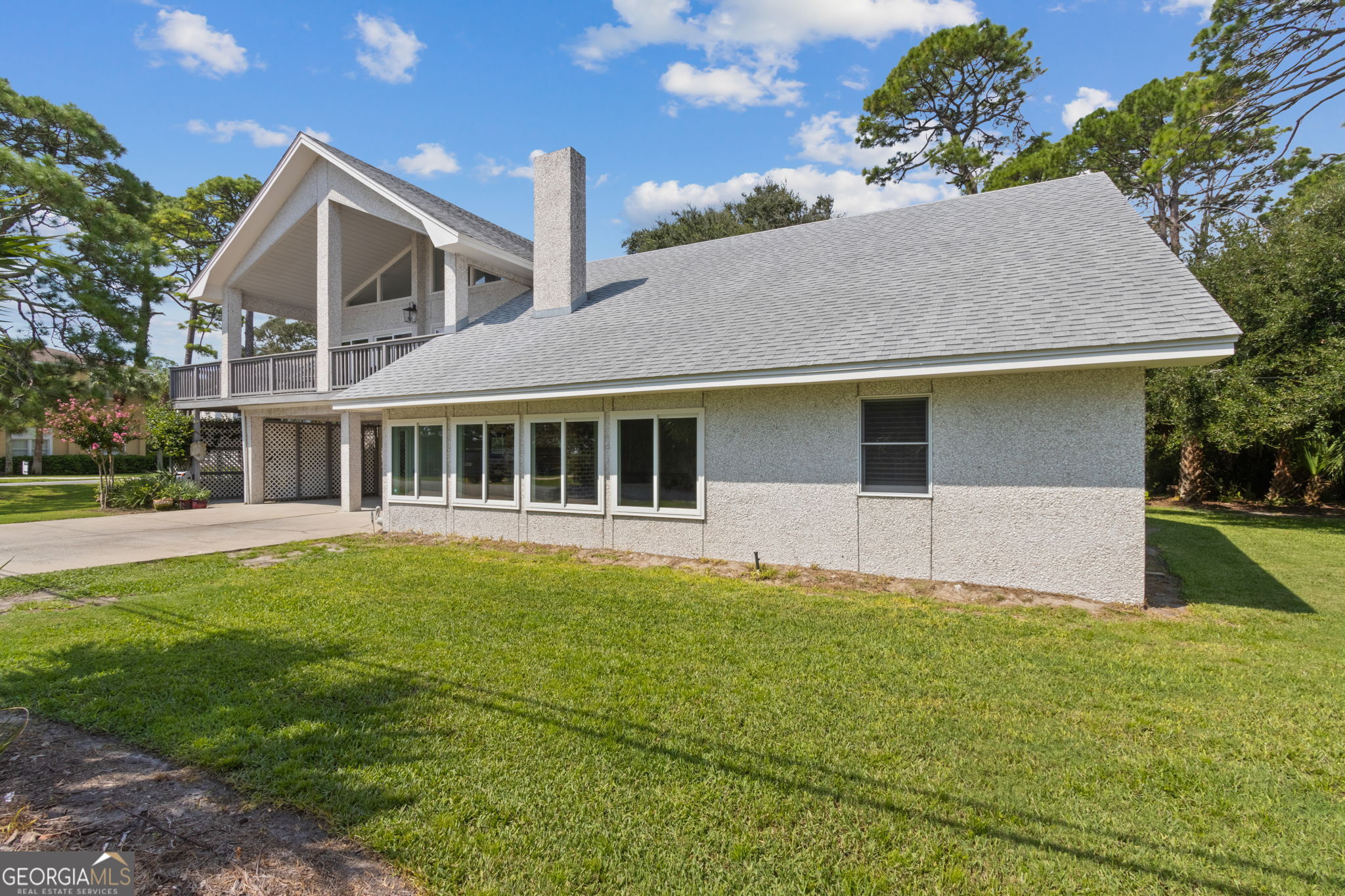 6 Stewart Lane Jekyll Island, GA 31527 - Photo 3 of 95 a front view of house with yard and trees in the background