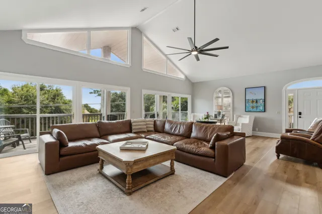 a front view of a house with a garden and trees