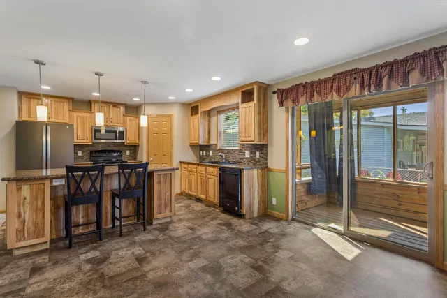a kitchen with refrigerator and chairs