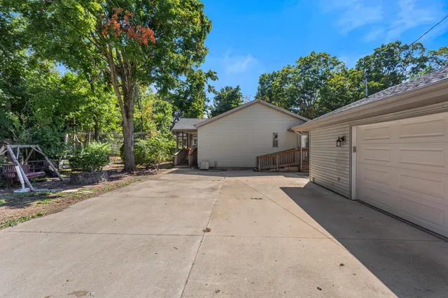 a view of a white house with a yard and large tree