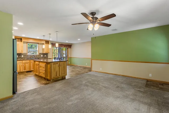 a view of a kitchen with kitchen island a sink stainless steel appliances and cabinets