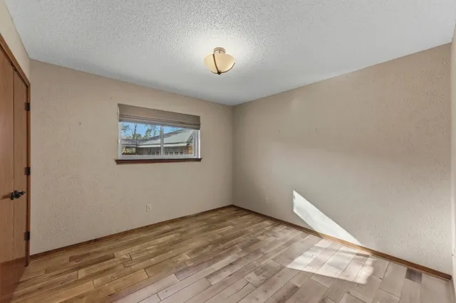a view of a yard in front of a house with a large tree