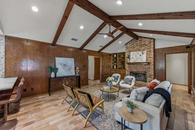 a living room with fireplace furniture and a wooden floor