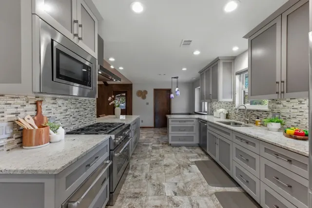 a kitchen with stainless steel appliances granite countertop a sink and a stove