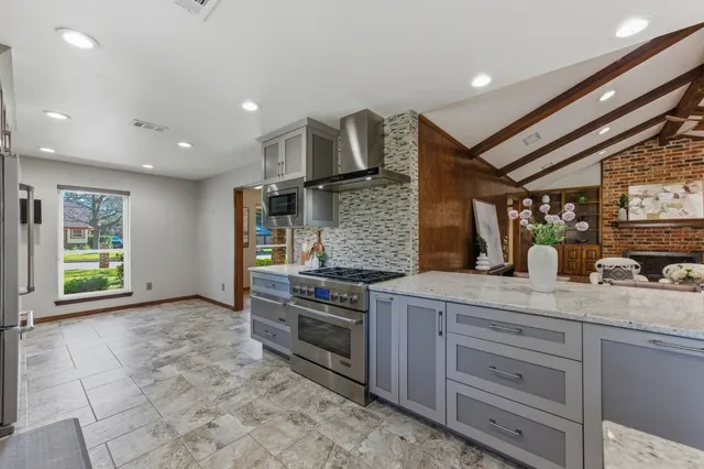 a kitchen with stainless steel appliances granite countertop a stove and cabinets