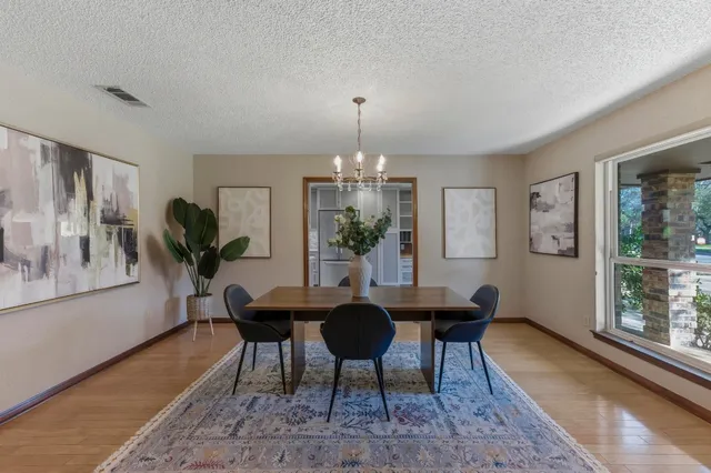 a dining room with furniture a chandelier and wooden floor