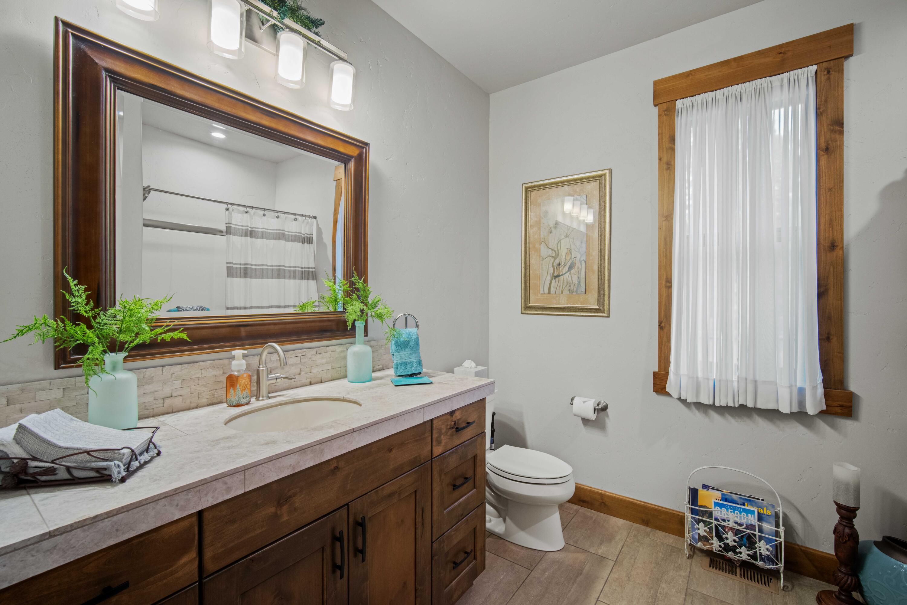 16927 Covina Road Bend, OR 97707 - Photo 24 of 54 Guest bathroom in this Bend, Oregon property with wood cabinetry, a generous vanity, and clean, well-kept finishes.
