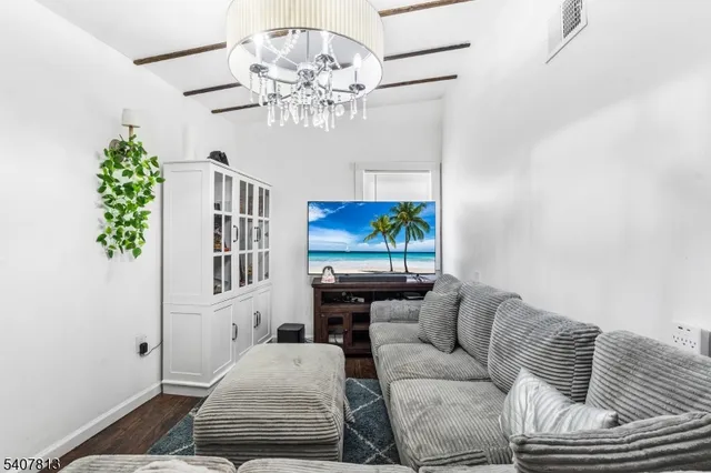 a living room with furniture a chandelier and a window