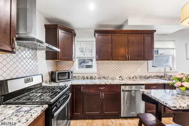 a kitchen with granite countertop a stove sink and cabinets