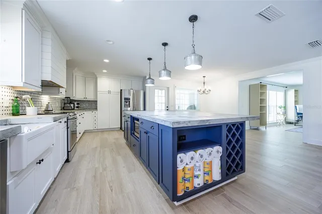 a kitchen with stainless steel appliances granite countertop a sink a stove top oven a counter space and cabinets