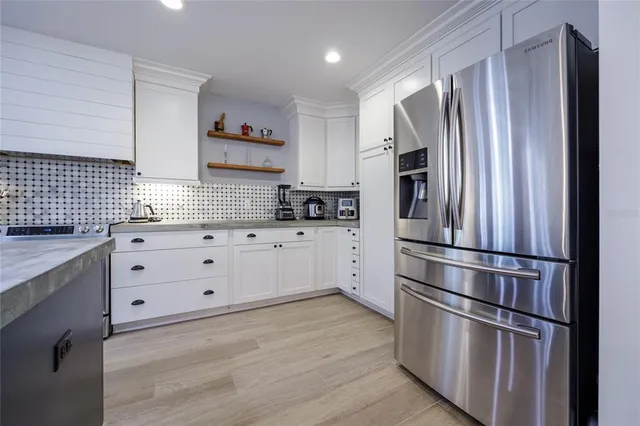 a dining room with wooden floor a chandelier a glass table and windows