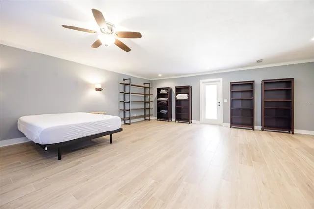 a view of a hallway with wooden floor and a bathroom